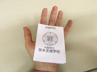 手のひらに乗せたメモパッドの写真