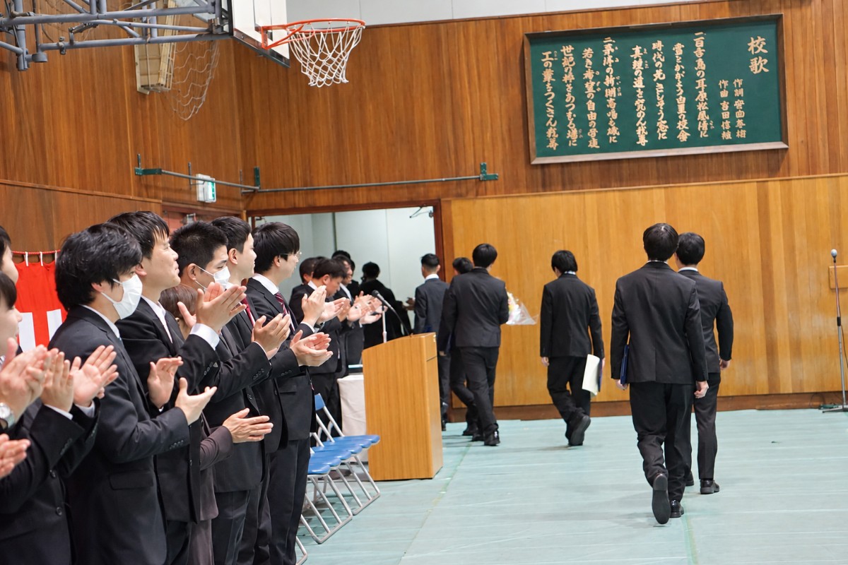 卒業式で卒業生を拍手で見送る様子